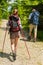 Young tourists with trekking poles in woods