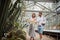 Young tourists in visit greenhouse with different kinds of plants. Botanical garden