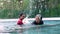 Young trainer helping senior woman in aqua aerobics and working out in the pool. old woman and mature man doing aqua aerobics