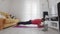 Young transgender homosexual man with make up doing static plank on mat with help of his instructor online on laptop