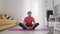 Young transgender homosexual man with makeup sits on fitness mat in butterfly pose