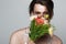 young transgender man holding flowers while