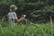 Young traveler and backpack is recording the adventure story there is forest is background,Thailand,Phang Nga,Koh Yao Yai