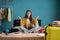 Young traveler woman meditating sitting near the suitcase on the bed at home, hold hands in yoga gesture. Female