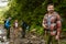 Young travelers with backpacks hiking together in forest