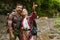 Young travelers wearing backpacks hiking in forest