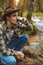 Young traveller drinking water from waterfall