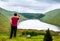 A young traveller man observing a lake in a deep valley covered