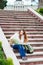 Young travelling woman sitting with map on stairs