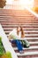 Young travelling woman sitting with map on stairs