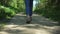 Young trendy woman walking on summer forest path trail Spbd. journey of girl in jeans and sneakers