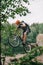 young trial biker performing stunt outdoors in front of