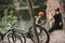 young trial bikers relaxing on rocky cliff after ride with bicycles