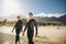 Young triathletes walking into the sea wearing wetsuit