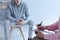 A young troubled man sitting on a chair in a blurred background.