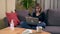 Young Turkish woman texting with her smartphone while sitting on the sofa.