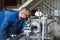 A young turner processes a metal workpiece on a mechanical lathe.