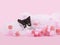 Young Tuxedo Kitten hiding inside of pink Tulle material, pink background