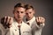 young twin brothers with similar appearance show fist, power