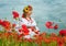 Young ukrainian woman on the field of poppies