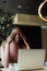 Young unhappy afro american woman with dreadlocks crying covering eyes with hands in coffee house closeup. Depressed