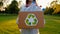 Young unidentified woman holds and hands a box with plastic bottles