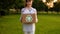 Young unidentified woman holds and hands a box with plastic bottles