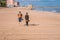 Young unrecognizable beautiful couple walking on beach. Casual style, vacation, sunny, bare foot