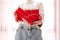 Young unrecognizable woman holds in a gift box in red paper. Christmas New Years present