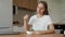 Young unsatisfied woman eats a salad sitting at home at the kitchen table