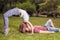 Young unusual kissing couple outdoors at park, in extreme position