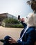 Young unusual man in horse head mask and elegant suit makes a photo by phone