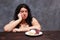 Young upset overweight woman bored of diets looking on sweets, c