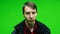 Young upset sad man looking at camera on green screen background. Unhappy alone. Chroma key