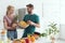 young vegan couple with fresh fruits and vegetables in kitchen