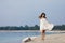 Young very beautiful girl with long hair in a white dress by the lake.