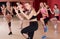 Young vigorous girls performing modern dance in fitness studio