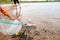 Young volunteers with garbage bags cleaning area in dirty beach of the lake, Volunteer concept.