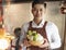 Young waiter bring vegetables for hot pot and serving customer in restaurant