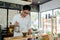 Young waiter making cup of coffee