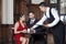 Young Waiter Serving Coffee To Tango Couple In Restaurant