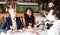 Young waitress in protective mask serving guests in restaurant