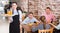 Young waitress is ready to serve salad and juice to young visitors