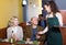 Young waitress taking order at table