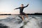 Young wakesurfer jumping on a wake board down the river