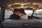 Young wedding couple sitting smiling inside retro car. just married embrace is hugging inside car. bride hugging groom who is driv