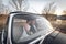 Young wedding couple sitting smiling inside retro car and looking at each other. just married embrace is hugging inside car. bride