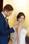 Young wedding couple smiling against a gold wall