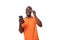 young well-groomed slender African guy dressed in an orange t-shirt holds a plastic credit card and a smartphone