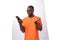 a young well-groomed slender African guy dressed in an orange T-shirt looks in surprise at a smartphone